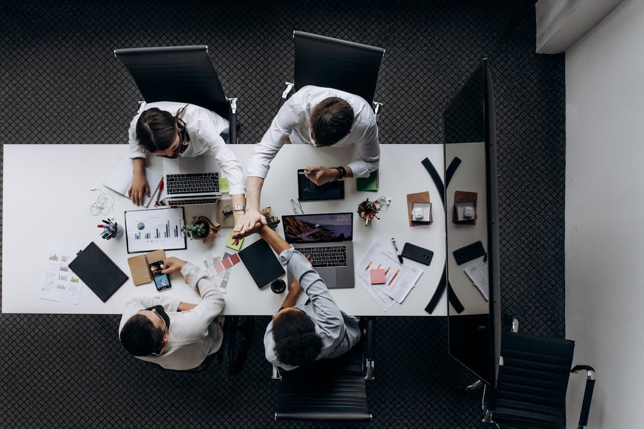 why-choose-us High angle view of colleagues collaborating around a conference table in a modern office setting.
